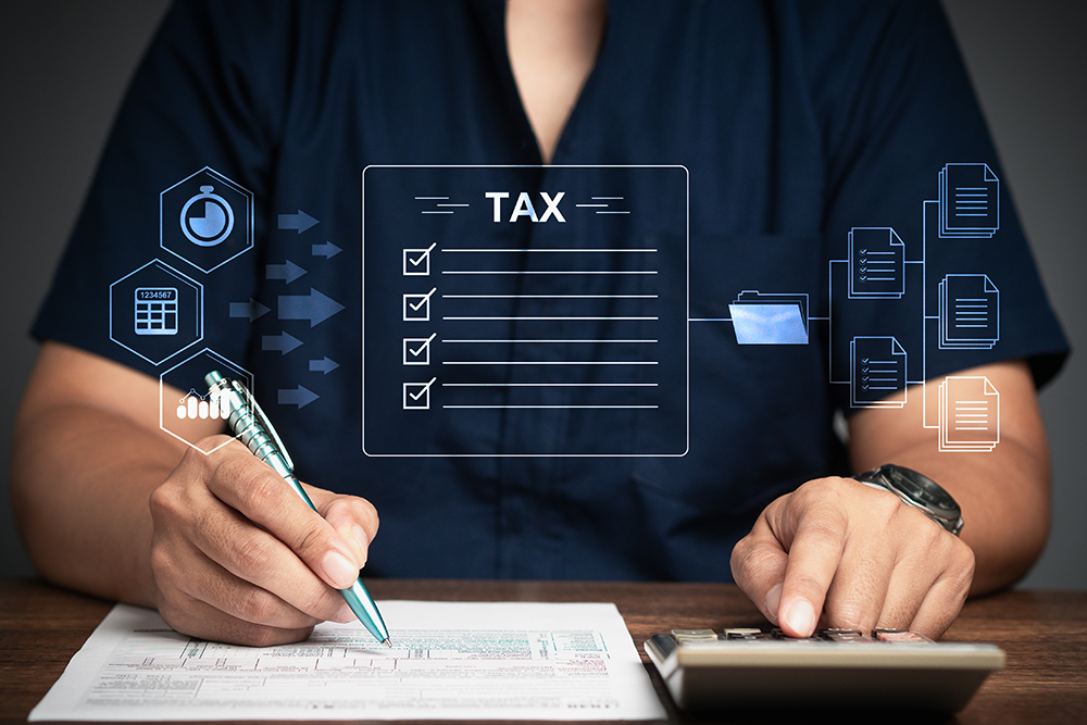 Businessman using a calculator to calculate tax while sitting at the table